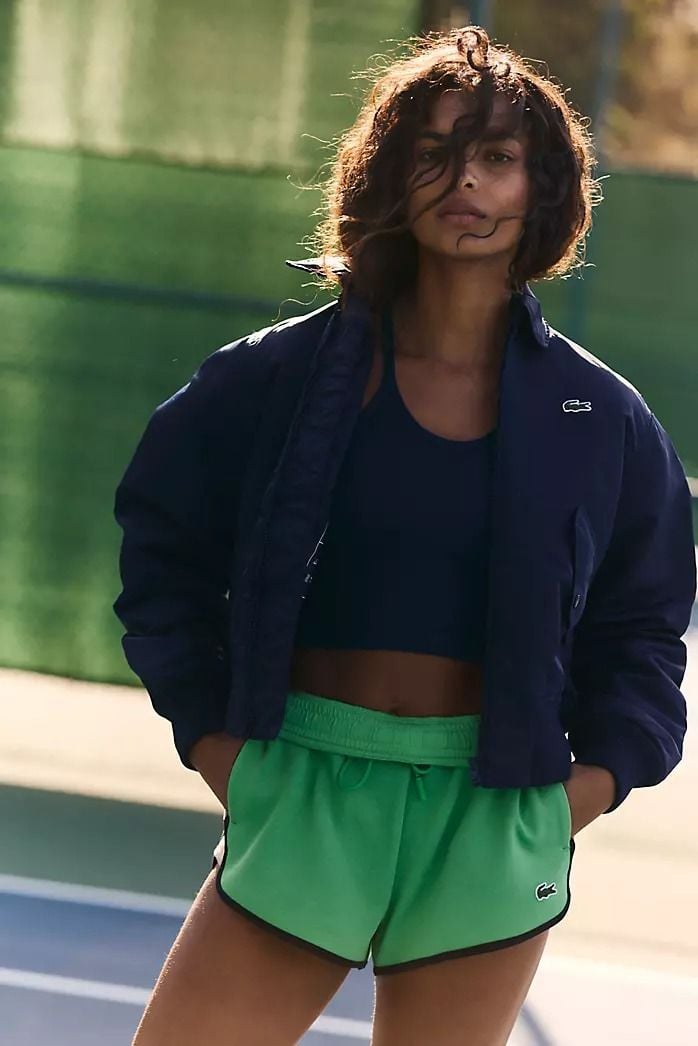 Woman standing on a sunlit tennis court
