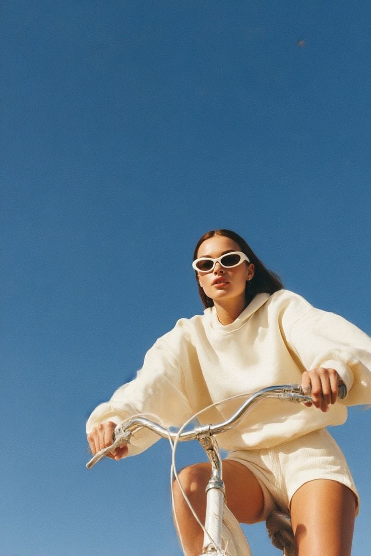 Woman cycling beneath a clear blue sky